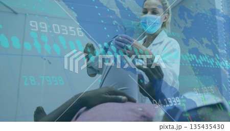 Assessing masked lab coat wearing doctor supporting patient raised leg in clinic with data overlays Assessing masked lab coat wearing doctor supporting patient raised leg in clinic with data overlays 135435430