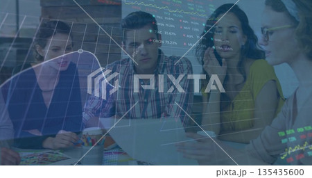 Collaborating professionals studying stock chart overlay at office meeting, with laptop Collaborating professionals studying stock chart overlay at office meeting, with laptop 135435600