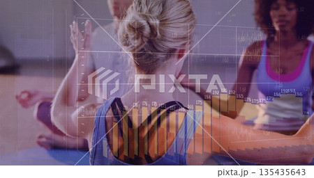 Woman wearing blue sportswear extending arms in yoga studio, with yoga mats and data overlays 135435643