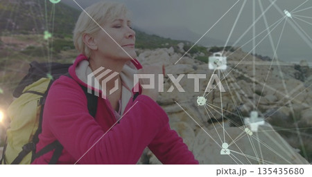 Inhaling woman wearing pink jacket carrying yellow-black backpack on rocky shore, network graphics Inhaling woman wearing pink jacket carrying yellow-black backpack on rocky shore, network graphics 135435680