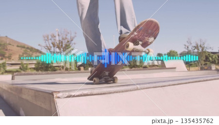 Balancing skateboarder in light pants, dark shoes sliding on ramp edge at skatepark, with waveform Balancing skateboarder in light pants, dark shoes sliding on ramp edge at skatepark, with waveform 135435762