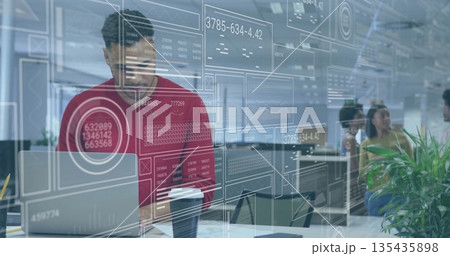 Leaning man wearing red sweater typing on laptop with coffee cup at open-plan desk, copy space Leaning man wearing red sweater typing on laptop with coffee cup at open-plan desk, copy space 135435898