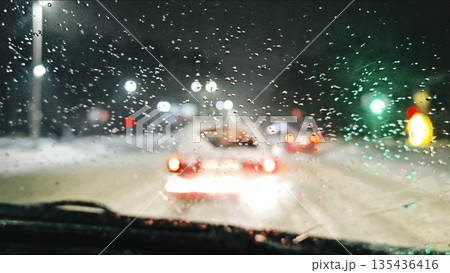POV moving traffic while snowing in in evening. POV traffic in a snowstorm in the city POV moving traffic while snowing in in evening. POV traffic in a snowstorm in the city 135436416