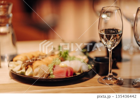 glass of dry White wine ripe grapes and bread on table in vineyard 135436442