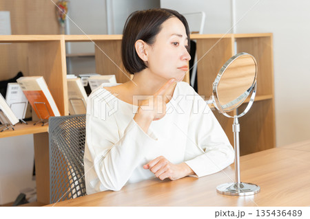 鏡を見て肌の調子を悩む気にする女性 鏡を見て肌の調子を悩む気にする女性 135436489