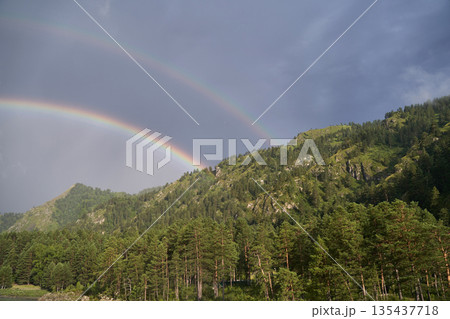 Double rainbow over lush green forest and mountain landscape in daylight Double rainbow over lush green forest and mountain landscape in daylight 135437718