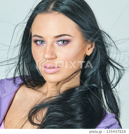 Young caucasian female with black hair and purple eye makeup posing confidently Young caucasian female with black hair and purple eye makeup posing confidently 135437828