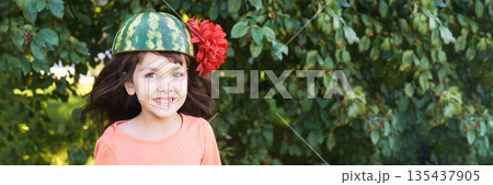 Joyful caucasian young girl wearing watermelon hat and red flower outdoors Joyful caucasian young girl wearing watermelon hat and red flower outdoors 135437905