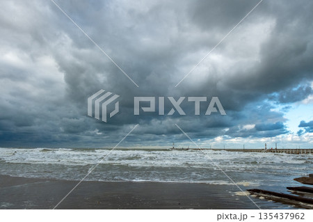 Wild coastal scene under dark menacing skies and tumultuous 135437962