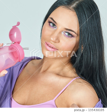 Young female with long black hair in purple top holding pink sippy cup Young female with long black hair in purple top holding pink sippy cup 135438105