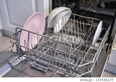 Open dishwasher with clean dishes inside kitchen appliance for efficient home 135438224