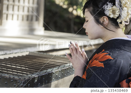 神社でお参りする着物姿の女性 135438469