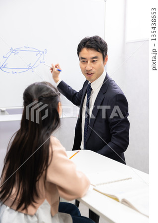 ホワイトボードを使って小学生に算数を教える塾講師 ホワイトボードを使って小学生に算数を教える塾講師 135438653