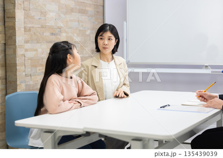 講師と面談する女子児童と母親 135439039