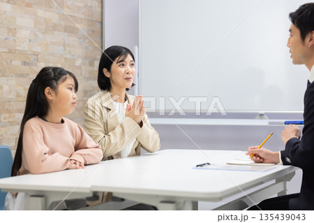 講師と面談する女子児童と母親 135439043