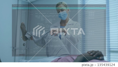 Bending female physician gently examining patient's knee in clinic exam room, with code overlay 135439124