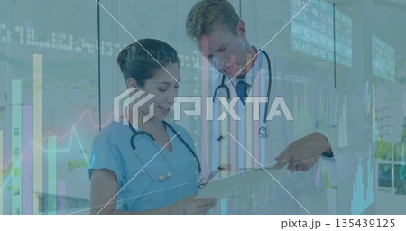 Nurse and doctor pointing and analyzing clipboard in corridor, with stethoscopes, digital overlays 135439125