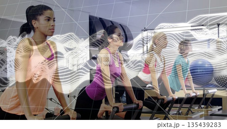 Leaning four women wearing leggings on reformers gripping footbars in fitness studio, with overlay Leaning four women wearing leggings on reformers gripping footbars in fitness studio, with overlay 135439283