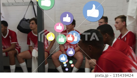 Sitting teenage soccer players wearing red jerseys on bench in locker room, with floating thumbs up Sitting teenage soccer players wearing red jerseys on bench in locker room, with floating thumbs up 135439424
