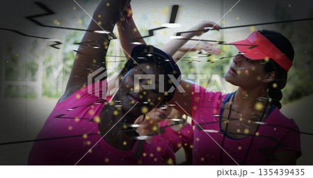 Stretching four women performing side stretches at park, with matching pink tops and athletic caps Stretching four women performing side stretches at park, with matching pink tops and athletic caps 135439435