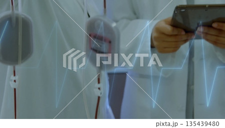 Staff in lab coats adjusting sensor pods and checking tablet in lab, with ECG waveform overlay Staff in lab coats adjusting sensor pods and checking tablet in lab, with ECG waveform overlay 135439480