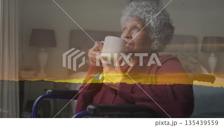 Senior woman in burgundy cardigan sitting in wheelchair drinking from ceramic mug in bedroom Senior woman in burgundy cardigan sitting in wheelchair drinking from ceramic mug in bedroom 135439559