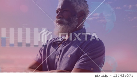Gazing man wearing shirt scanning beach horizon at dusk, with bar chart and world map overlays Gazing man wearing shirt scanning beach horizon at dusk, with bar chart and world map overlays 135439573