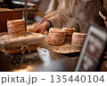 Freshly baked cylindrical pastries dusted with flour on wooden table in bakery setting 135440104