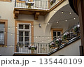 Cozy courtyard with string lights and flower pots during winter season with snow on the ground 135440109