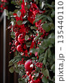 Festive red and green holiday wreath with ornaments and ribbons, close-up view with copy space 135440110