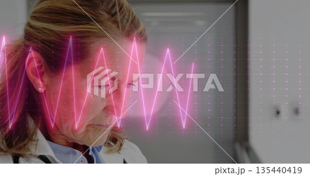 Reviewing patient data doctor wearing lab coat and stethoscope analyzing ECG waveform in clinic Reviewing patient data doctor wearing lab coat and stethoscope analyzing ECG waveform in clinic 135440419