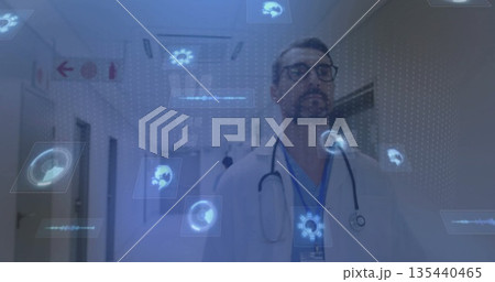 Scanning doctor in lab coat and stethoscope exploring holograms in hospital corridor, with panels 135440465