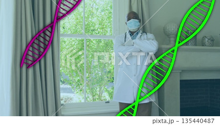 Doctor standing in office wearing coat, stethoscope, mask and gloves with floating DNA graphics Doctor standing in office wearing coat, stethoscope, mask and gloves with floating DNA graphics 135440487