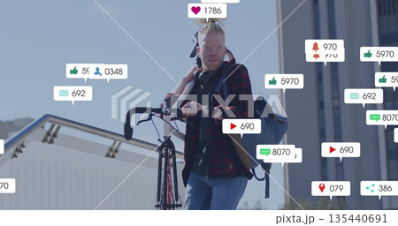 Carrying bicycle cyclist walking on bridge, with headphones and floating social media icons Carrying bicycle cyclist walking on bridge, with headphones and floating social media icons 135440691