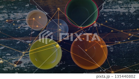 Displaying bowls with green bowl with red rim on chipped green table, with golden network overlay 135440802