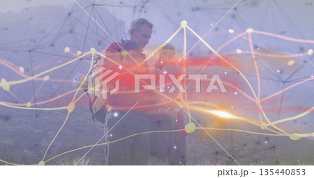 Hiking couple studying network overlay on misty mountain slope, with backpacks and curve plots 135440853