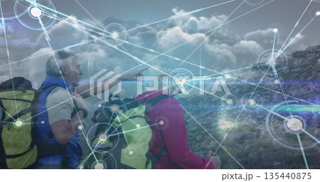 Pointing senior hikers scanning rocky hillside trail with backpacks and digital overlay, copy space Pointing senior hikers scanning rocky hillside trail with backpacks and digital overlay, copy space 135440875
