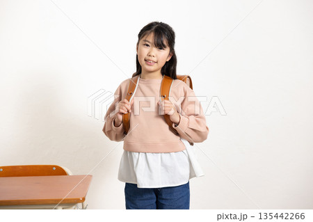 学校の教室でランドセルを背負って微笑む小学生の女の子 135442266