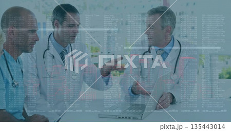 Analyzing data, three doctors in lab attire meeting in conference room with laptop and stethoscopes 135443014