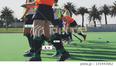 Sprinting teenage athletes practicing field hockey on coastal turf pitch, with floating data labels Sprinting teenage athletes practicing field hockey on coastal turf pitch, with floating data labels 135443062