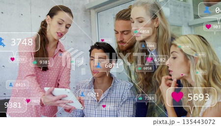 Group of six colleagues reviewing metrics on white tablet in office, with social media overlays Group of six colleagues reviewing metrics on white tablet in office, with social media overlays 135443072