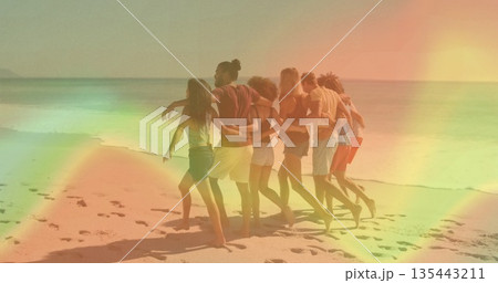 Walking group of seven friends in swimwear draping arms on sandy shoreline, vacation mood 135443211