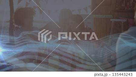 Sitting four friends chatting around wooden picnic table inside thatched beach hut, with ocean view Sitting four friends chatting around wooden picnic table inside thatched beach hut, with ocean view 135443243