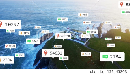 Standing white lighthouse with red trim and building on green sea cliff, with digital overlay icons 135443268