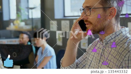 Calling man wearing glasses and checked shirt with smartphone in modern office, with network icons 135443332