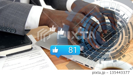 Typing suited professional hands interacting with laptop at office workspace, with thumbs-up icons 135443377