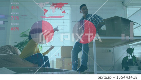 Unpacking colleagues arranging boxes in new studio space by desk with house model, digital overlays Unpacking colleagues arranging boxes in new studio space by desk with house model, digital overlays 135443418