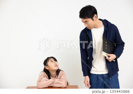 教室で会話する男性教諭と小学生の女の子 教室で会話する男性教諭と小学生の女の子 135443866