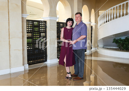 A full-length portrait of a married couple in casual wear, indoors A full-length portrait of a married couple in casual wear, indoors 135444029
