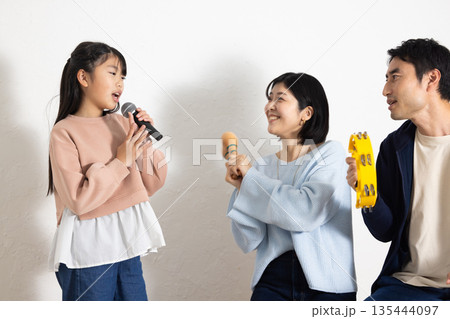 カラオケを楽しむ小学生の女の子と盛り上げる両親 135444097